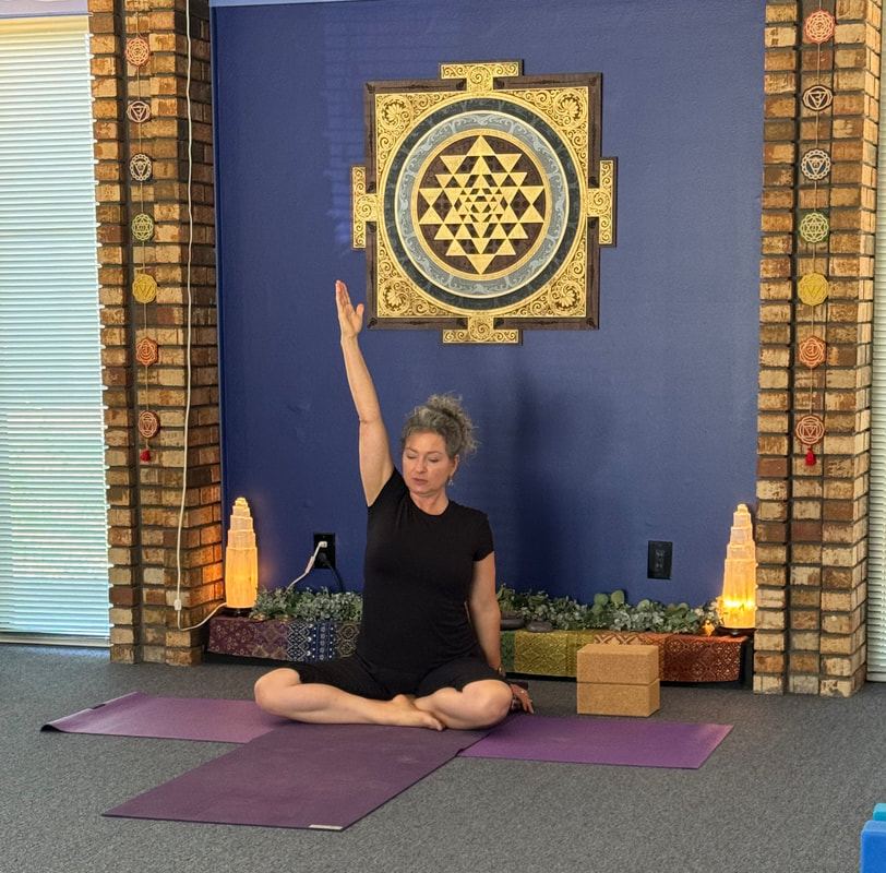 A practitioner in a seated stretch at the Painted Lotus studio